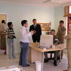 Професионалисти в сферата на недвижимите имоти в Алания обсъждат възможности за ваканционни имоти в модерен офис.
